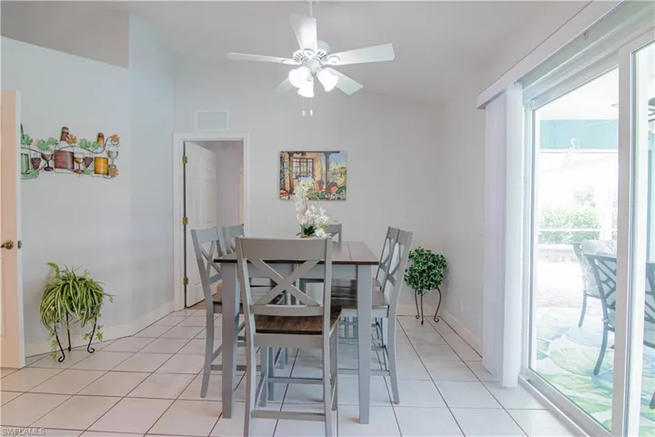 Tiled dining area with vaulted ceiling and ceiling fan