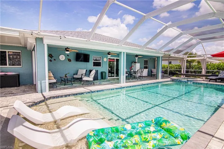 View of pool with ceiling fan, central AC unit, glass enclosure, and a patio area