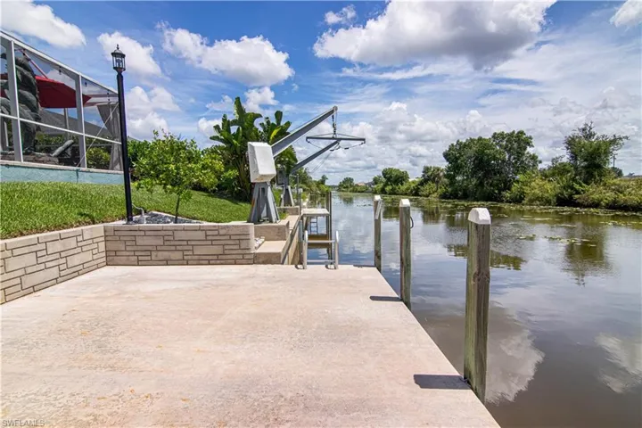 View of dock with a lanai and a water view