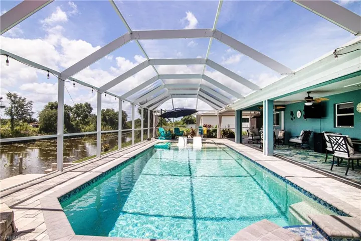 View of swimming pool featuring a lanai, an outdoor hangout area, a patio area, and ceiling fan
