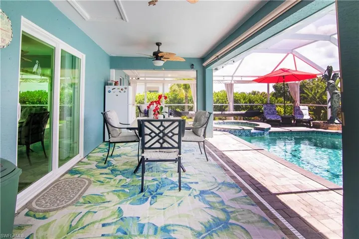 View of swimming pool with ceiling fan, an in ground hot tub, and a patio