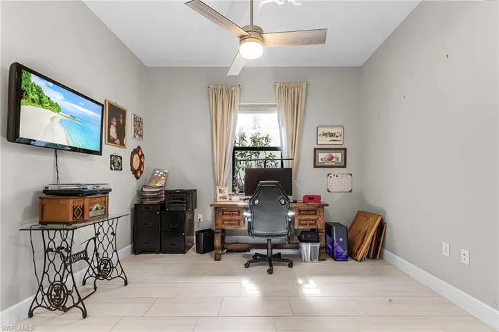 Home office with baseboards and ceiling fan