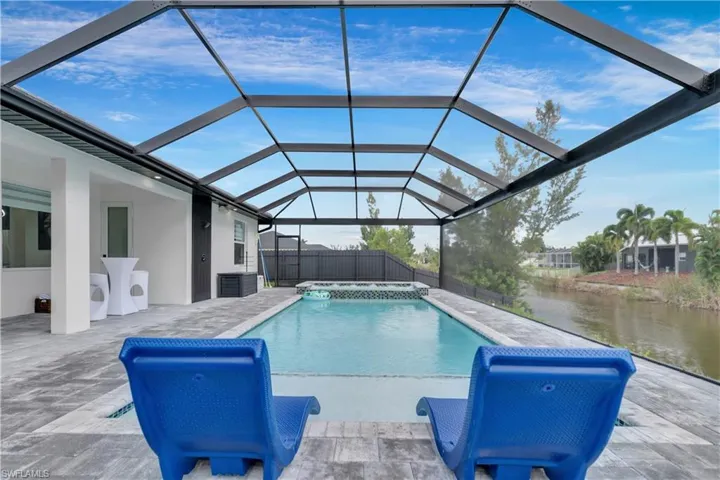View of swimming pool with a lanai, a water view, cooling unit, and a patio area