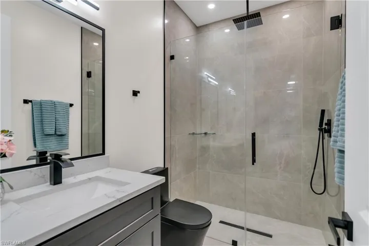 Full bathroom with vanity, a shower stall, and toilet