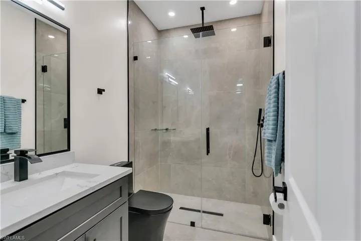 Bathroom featuring recessed lighting, toilet, a shower stall, and vanity