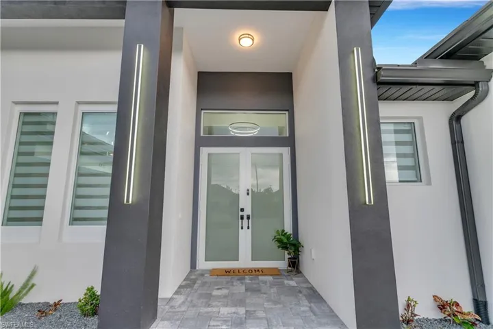Doorway to property featuring french doors and stucco siding