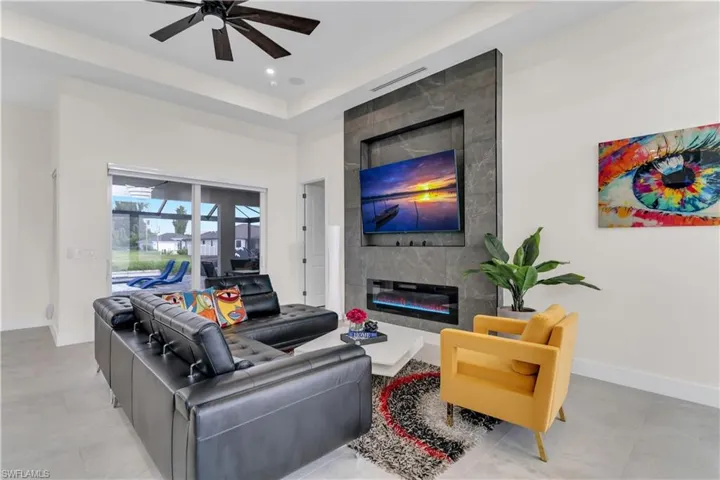 Living room with baseboards, recessed lighting, ceiling fan, and a fireplace