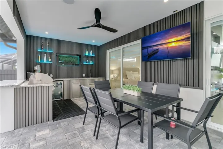 View of patio with area for grilling, a ceiling fan, and outdoor dining space