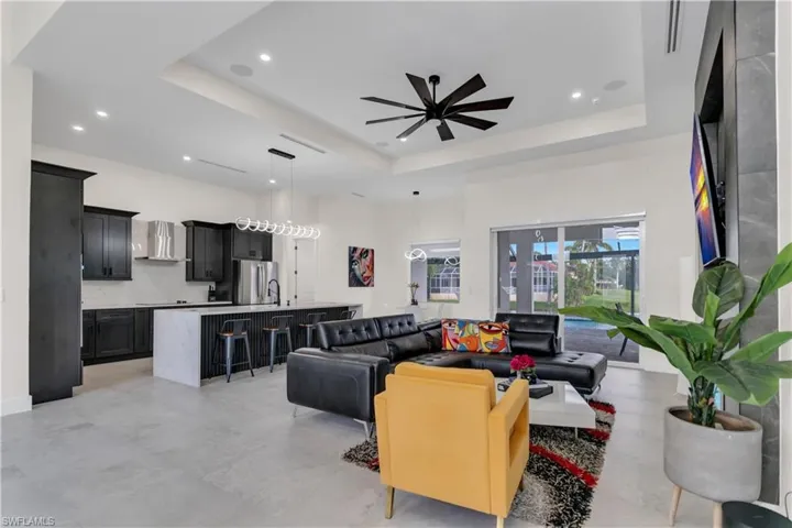 Living area featuring recessed lighting, a raised ceiling, ceiling fan, and a towering ceiling