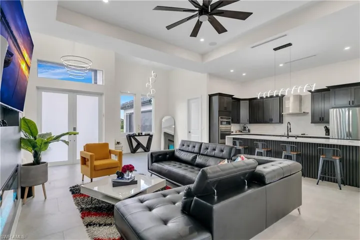 Living room with visible vents, ceiling fan, a high ceiling, recessed lighting, and french doors
