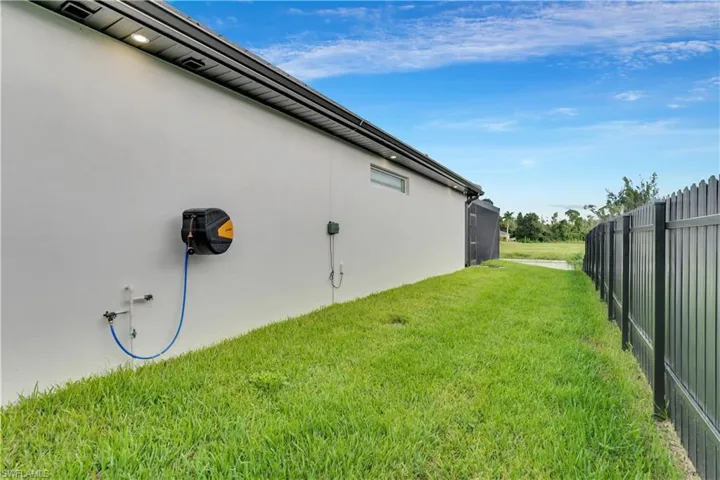 View of home's exterior featuring fence, stucco siding, and a yard