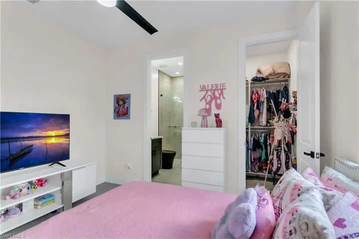 Bedroom with a ceiling fan, baseboards, ensuite bathroom, and a closet