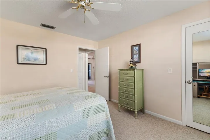 Bedroom featuring a textured ceiling, light carpet, and ceiling fan