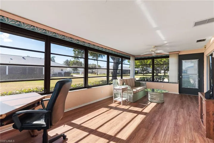 Sunroom featuring baseboards and wood finished floors