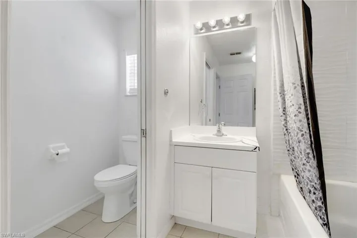 Full bathroom featuring vanity, tile patterned floors, and shower / bath combo
