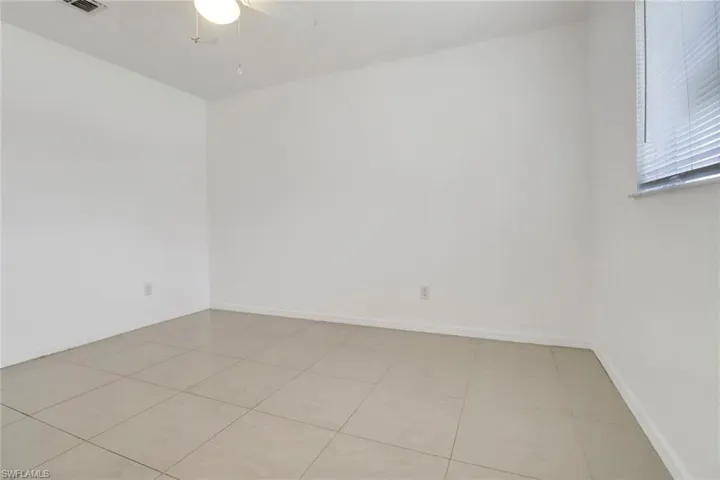 Spare room with a ceiling fan and light tile patterned floors