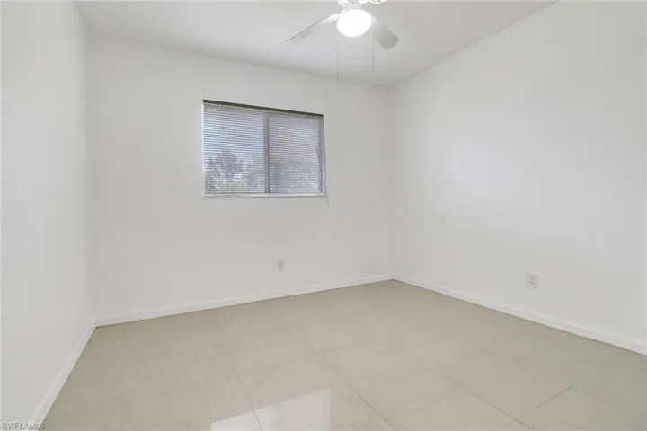 Unfurnished room featuring ceiling fan and baseboards