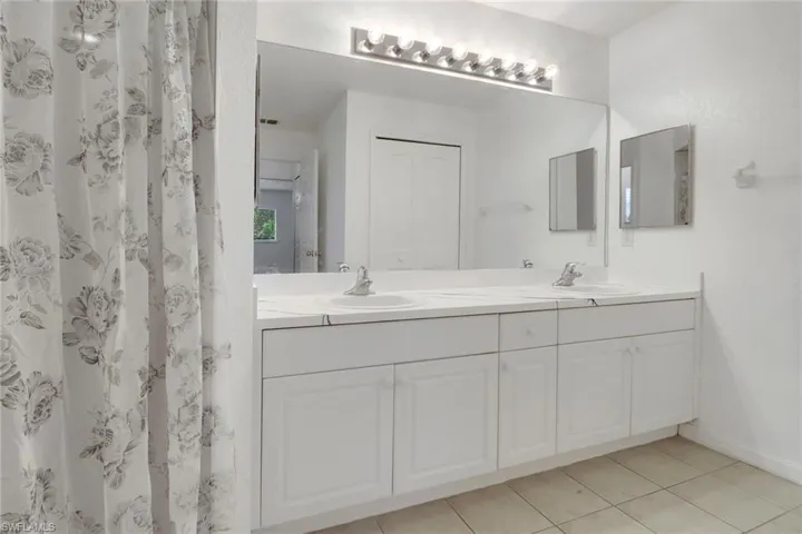 Full bath featuring double vanity and tile patterned floors