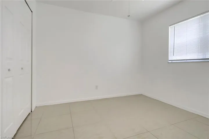 Unfurnished bedroom featuring light tile patterned floors and a closet
