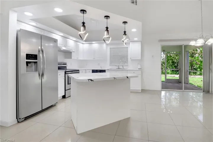 Kitchen featuring appliances with stainless steel finishes, light tile patterned floors, under cabinet range hood, white cabinetry, and recessed lighting