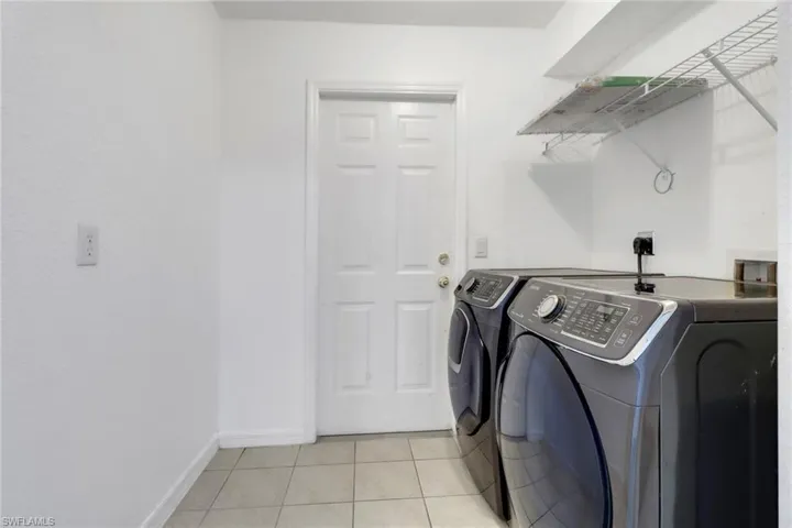Washroom featuring washer and clothes dryer and light tile patterned floors