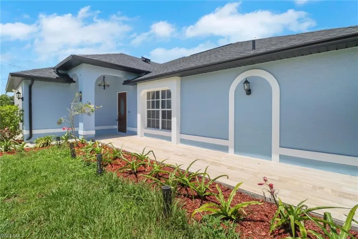 View of front of house featuring stucco siding and roof with shingles