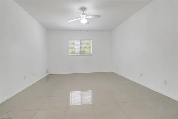 Spare room with a ceiling fan and light tile patterned floors