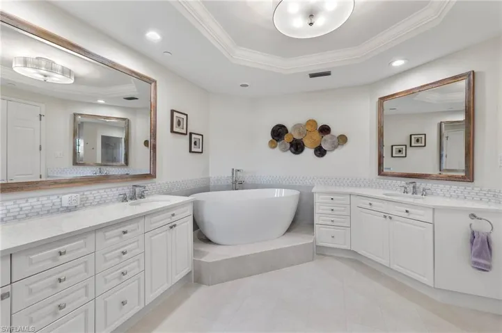Bathroom with a tray ceiling, tile patterned floors, and tasteful backsplash