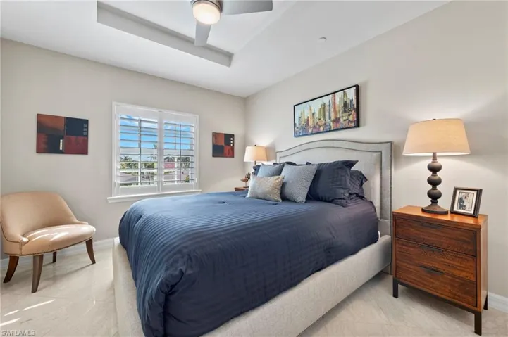 Tiled bedroom featuring ceiling fan
