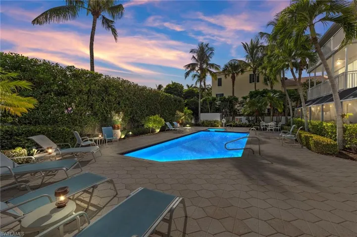 Pool at dusk featuring a patio