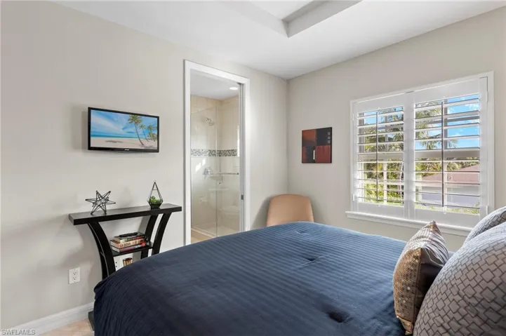 Bedroom featuring connected bathroom and light tile patterned floors