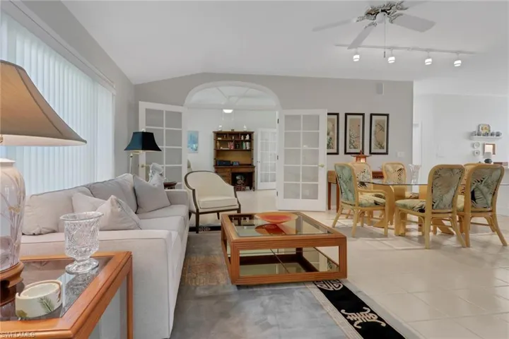Living room featuring vaulted ceiling and ceiling fan