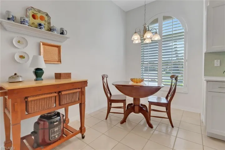 Dining area with light tile patterned floors and a chandelier