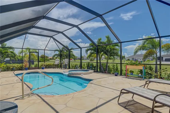 View of swimming pool featuring a screened in lanai, and a pool with connected hot tub