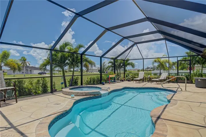 View of swimming pool featuring a lanai, a patio area, a pool with connected hot tub, and a screened enclosure