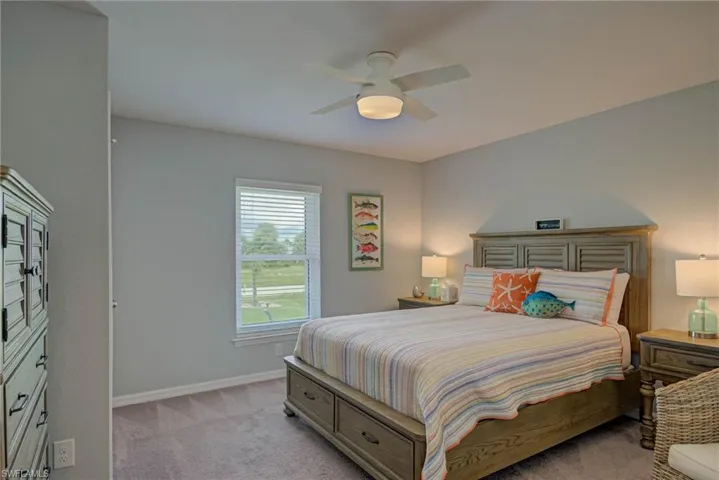 Bedroom with light carpet and a ceiling fan
