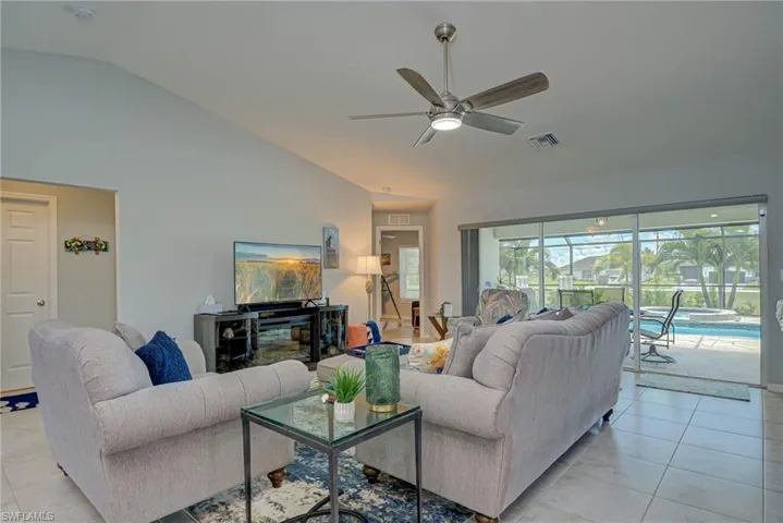 Living room featuring light tile patterned flooring, a ceiling fan, and high vaulted ceiling