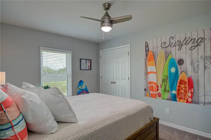 Bedroom with a ceiling fan, carpet, and a closet