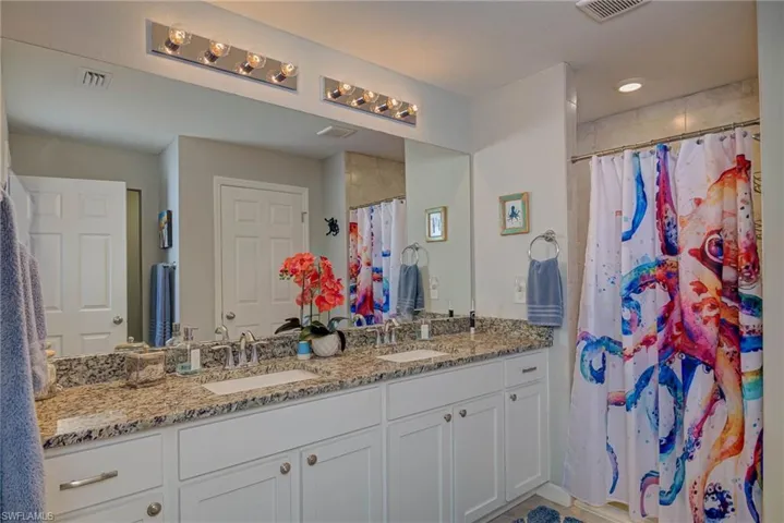 Full bath with double vanity and curtained shower