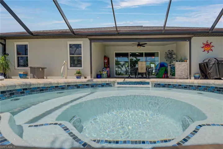 Swimming pool with a lanai, ceiling fan, and a screened in cage