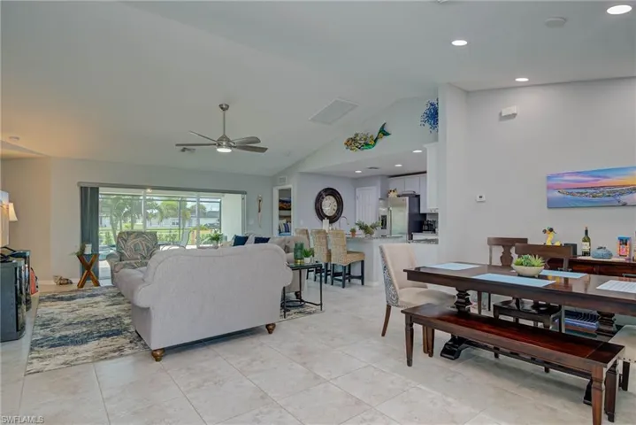 Living room featuring high vaulted ceiling, ceiling fan, recessed lighting, and light tile patterned floors