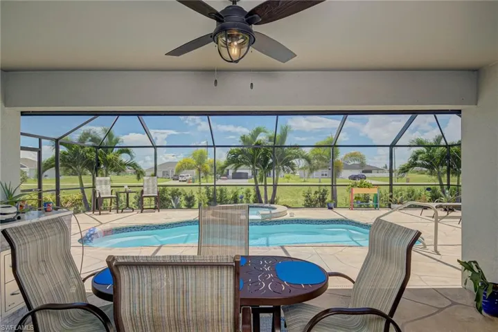 View of pool with a sunroom, a patio area, and screened enclosure