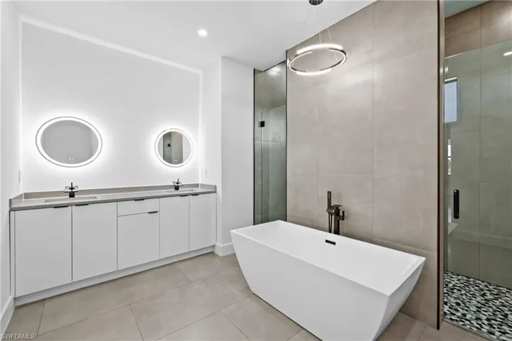 Bathroom with tile flooring, independent shower and bath, and oversized vanity