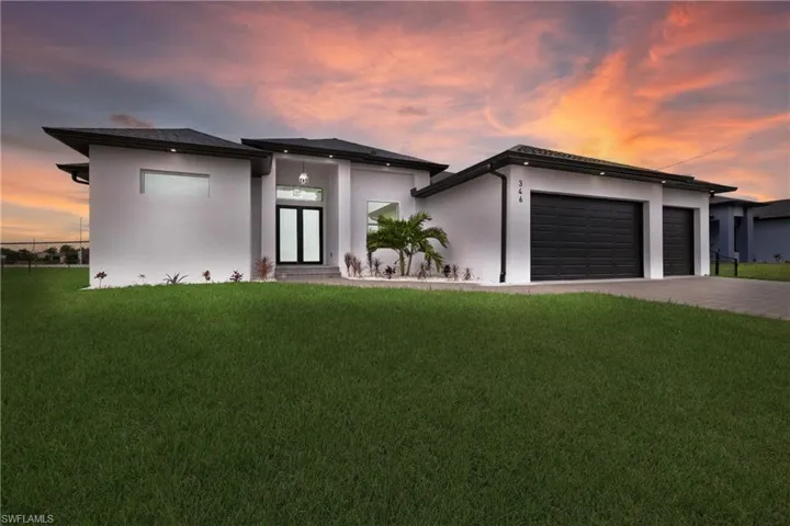 View of front facade with a garage and a yard
