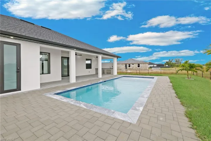 View of pool with a patio area and a yard