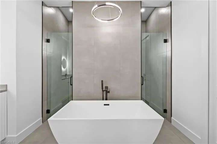 Bathroom with tile floors, separate shower and tub, and vanity