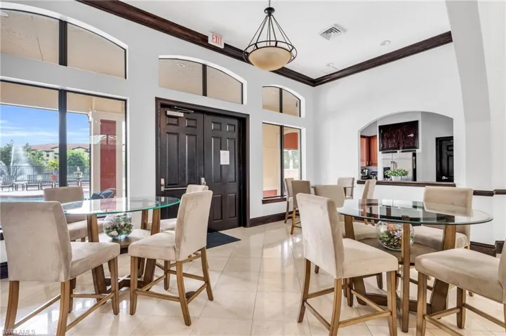 Dining space with crown molding, a healthy amount of sunlight, and light tile patterned floors