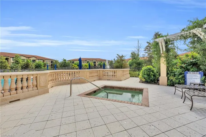 View of swimming pool featuring a patio and a hot tub