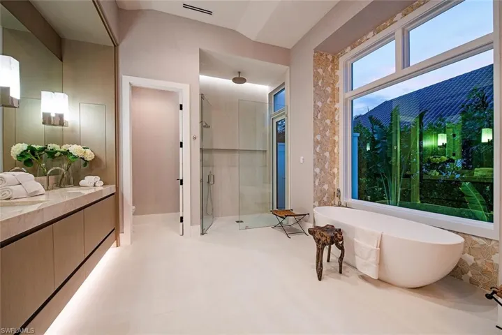 Bathroom with a shower stall, vanity, a freestanding bath, toilet, and visible vents