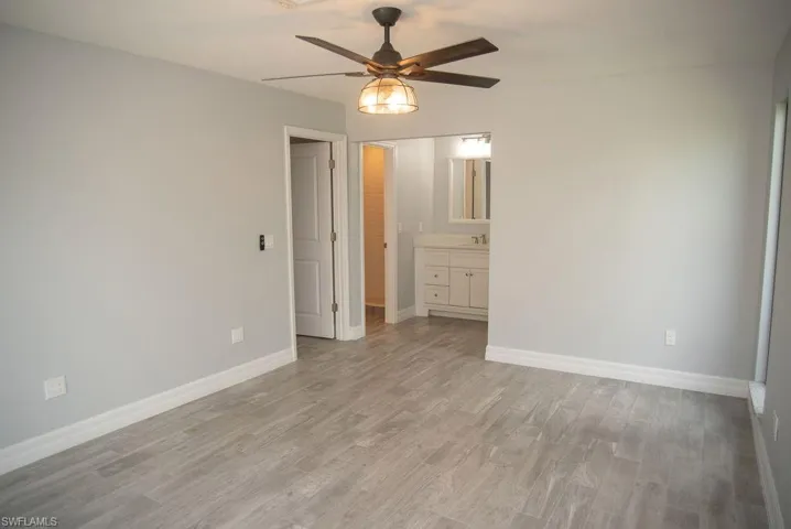 Unfurnished room featuring sink, light hardwood / wood-style floors, and ceiling fan